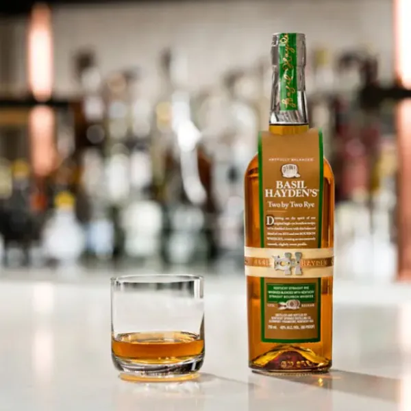 Two by Two Rye Bottle with a glass filled with the bourbon on a bottle