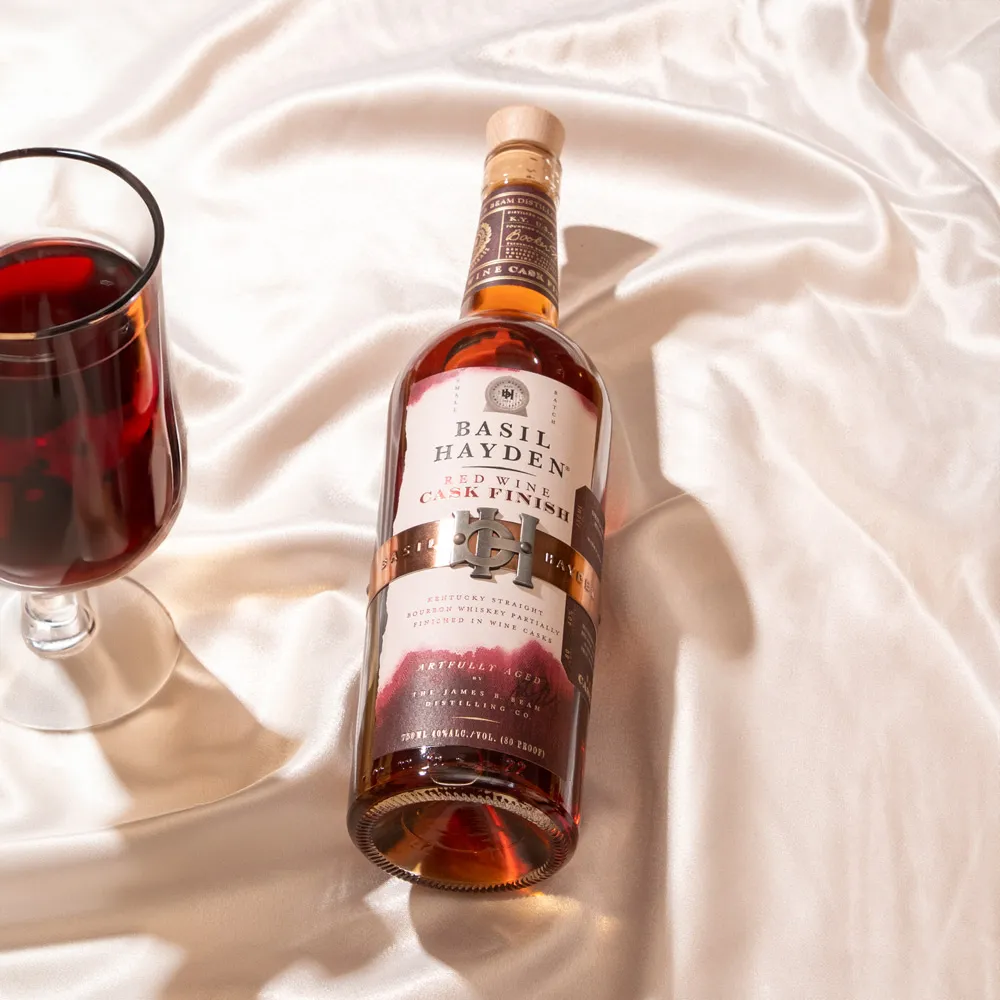 Basil Hayden® Red Wine Cask Finish Bourbon bottle and a glass ready to drink