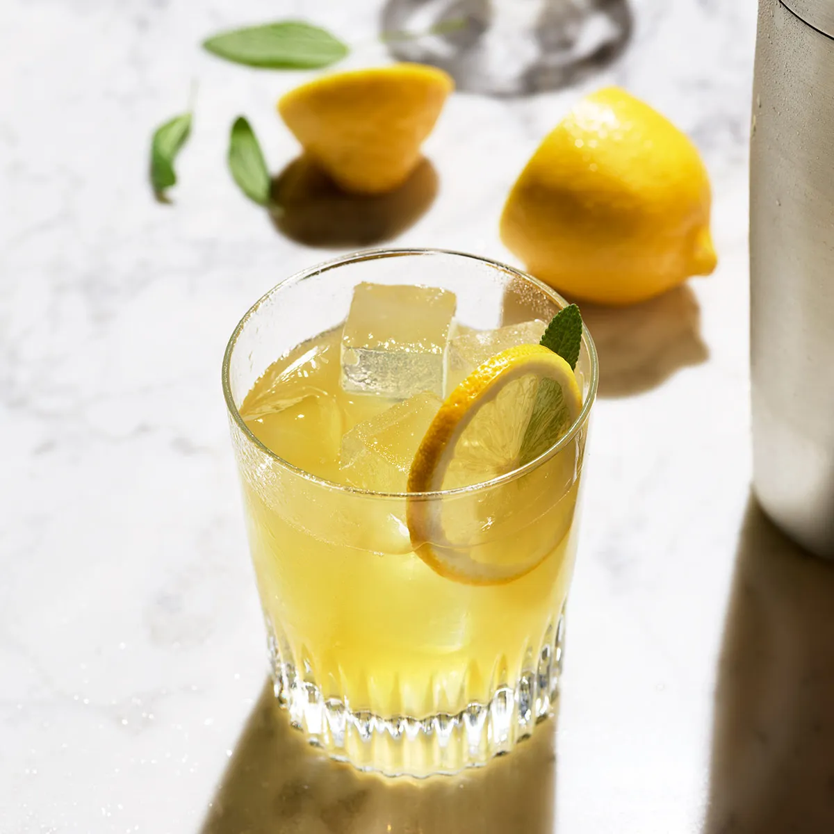 A glass of bourbon whiskey cocktail garnish with lemon peel and ice